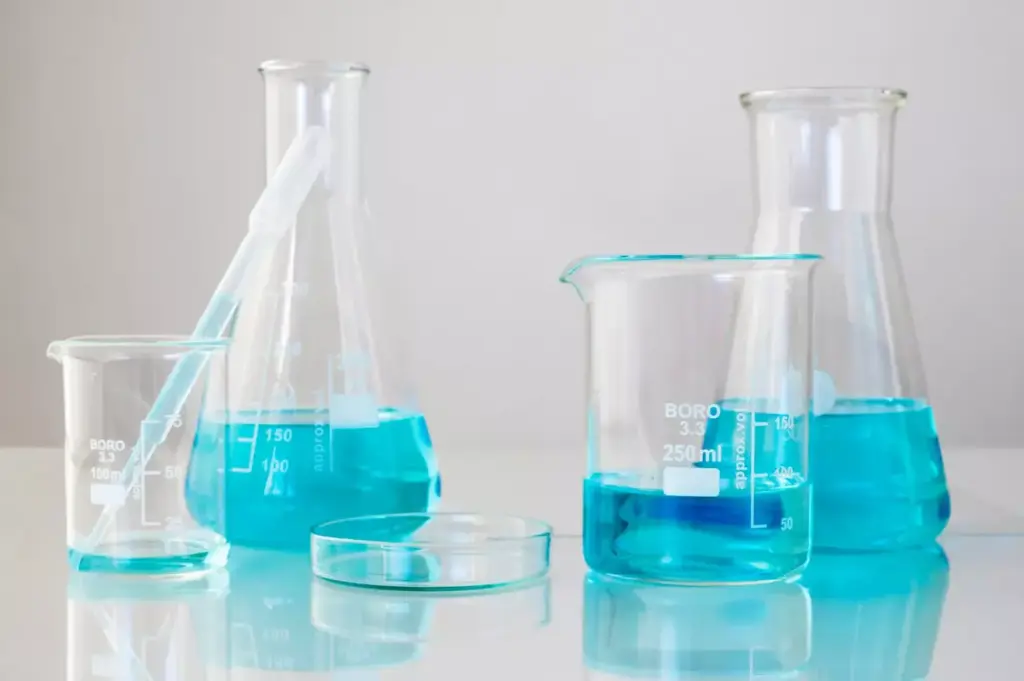 A clean, well-lit laboratory setting. On a stainless steel countertop, two glass beakers containing distinct chemical compounds: one with a clear, amber liquid representing acetaminophen (Tylenol Arthritis), the other with a fizzing, effervescent solution depicting non-steroidal anti-inflammatory drugs (NSAIDs). The beakers are positioned side by side, illuminated by bright, directional lighting that casts crisp shadows, emphasizing their contrasting properties. The background is a pristine, white-tiled wall, creating a clinical, professional atmosphere. The composition is balanced, with the two beakers occupying the center of the frame, inviting the viewer to examine and compare the distinct substances.