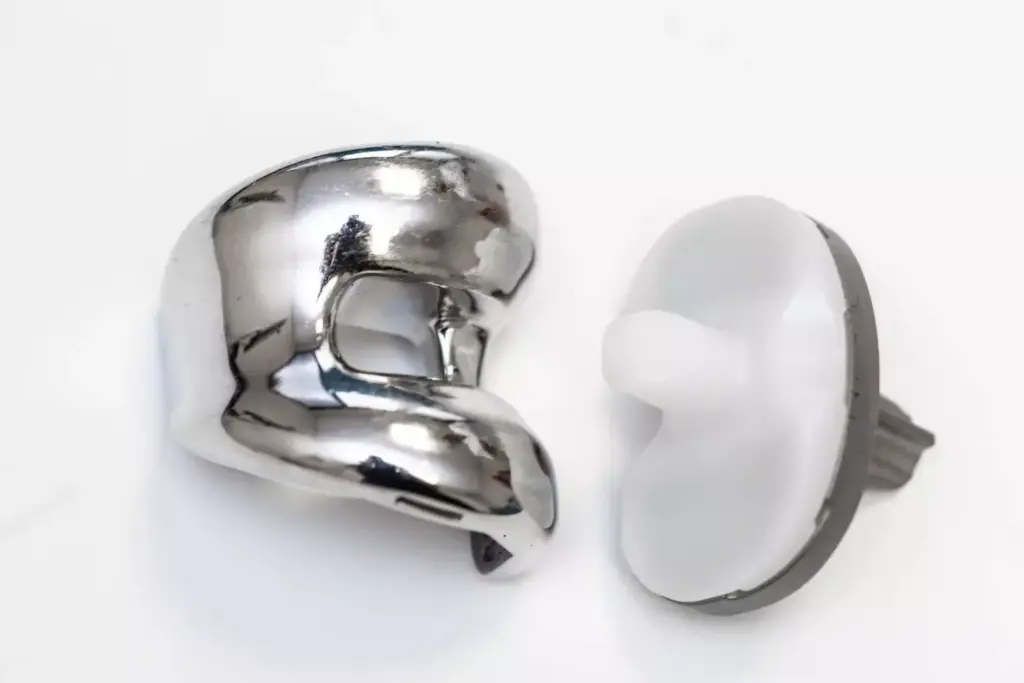 A detailed comparison of various knee replacement device materials, including titanium, cobalt-chrome, ceramic, and high-density polyethylene, displayed against a clean, clinical backdrop. The devices are arranged in the foreground, illuminated by soft, diffused lighting to highlight their intricate designs and finishes. The middle ground showcases a technical blueprint or schematic, providing additional context, while the background features a subtle, blurred medical or laboratory setting, conveying a sense of scientific precision and innovation. The overall composition emphasizes the technical aspects and material properties of these advanced orthopedic implants.