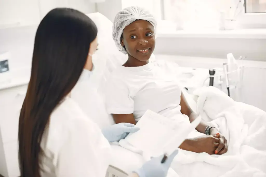 A serene hospital ward bathed in soft, warm lighting. In the foreground, a group of women gather in a supportive embrace, their faces reflecting understanding and empathy. In the middle ground, medical professionals in white coats move with quiet efficiency, their expressions conveying compassion. In the background, a panoramic window offers a glimpse of a verdant landscape, symbolizing the resilience and hope that permeates this space of healing. The overall atmosphere is one of unity, care, and the unwavering strength of the breast cancer community. A serene hospital ward bathed in soft, warm lighting. In the foreground, a group of women gather in a supportive embrace, their faces reflecting understanding and empathy. In the middle ground, medical professionals in white coats move with quiet efficiency, their expressions conveying compassion. In the background, a panoramic window offers a glimpse of a verdant landscape, symbolizing the resilience and hope that permeates this space of healing. The overall atmosphere is one of unity, care, and the unwavering strength of the breast cancer community.