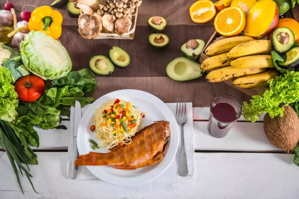 A sunlit kitchen counter displaying an array of fresh, vibrant ingredients - lean protein like grilled chicken or fish, whole grains like brown rice or quinoa, and an assortment of nutrient-dense vegetables like broccoli, spinach, and carrots. The scene has a warm, inviting atmosphere, conveying the idea of nourishing, recovery-boosting meals. The lighting is soft and natural, highlighting the colors and textures of the foods. The camera angle is slightly elevated, providing a clear, appetizing view of the arrangement. This image aims to inspire and inform readers about the best post-prostate surgery foods to aid in a speedy and healthy recovery.