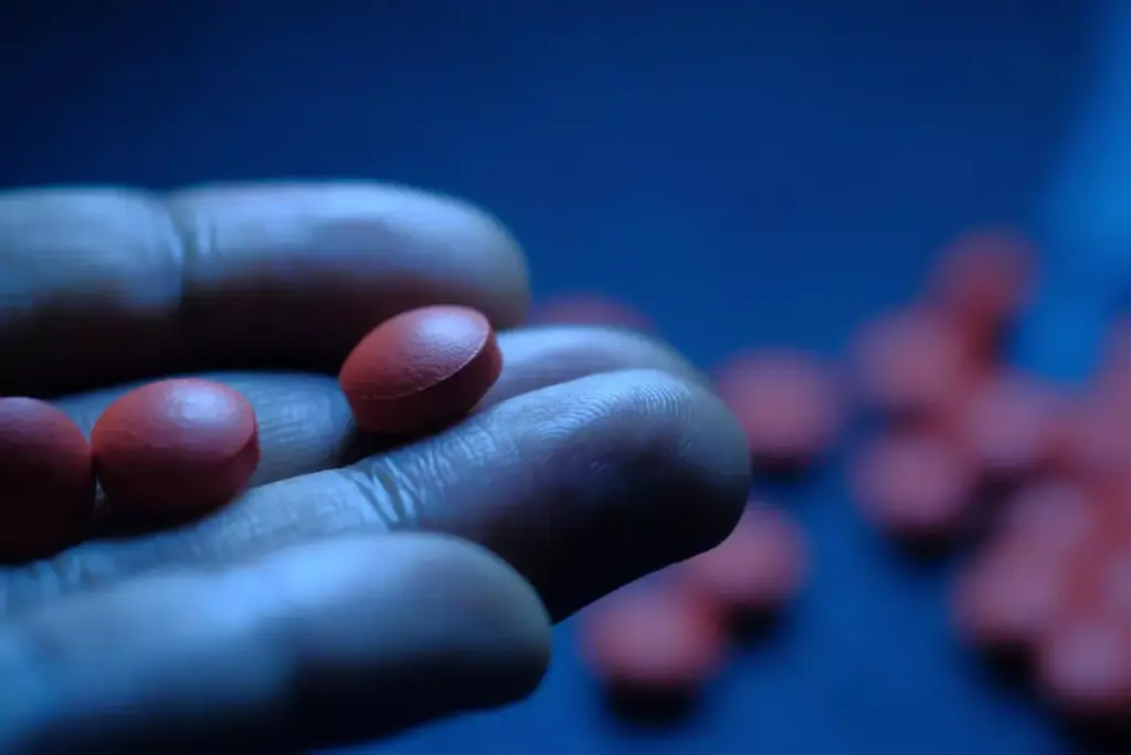 Detailed close-up of a selection of chemotherapy drugs and pills used to treat ovarian cancer. The foreground prominently features various pill capsules, tablets, and vials against a blurred background. The lighting is soft and diffuse, creating a serene and clinical atmosphere. The depth of field is shallow, drawing the viewer's focus to the medicinal details. The overall palette is muted, with shades of white, gray, and blue predominating. The composition is balanced and symmetrical, conveying a sense of order and precision in the medical treatment. The angle is slightly elevated, suggesting the perspective of a healthcare professional examining the essential chemotherapy components.
