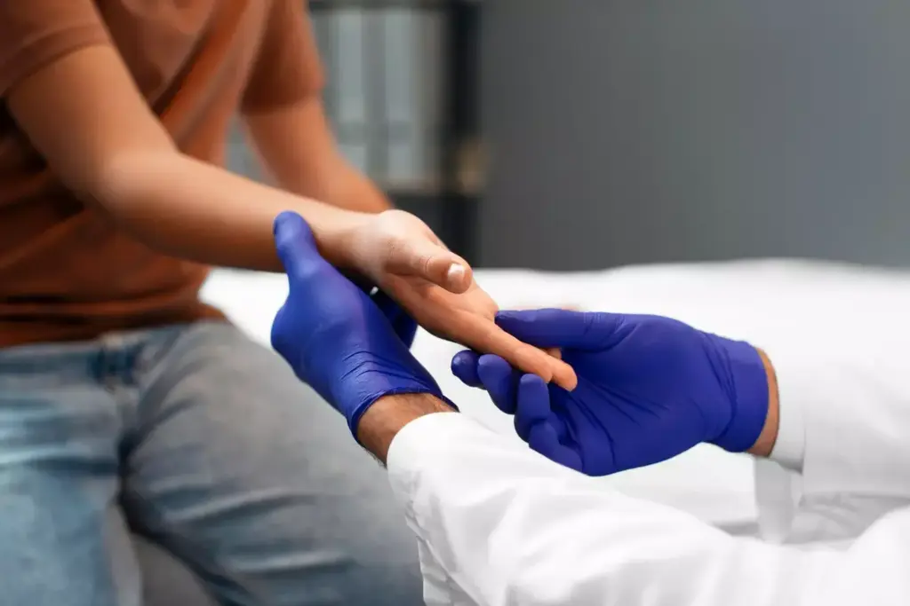 Detailed cross-section illustration of a carpal tunnel release surgery procedure. The foreground depicts the surgeon's hands delicately operating on the exposed wrist, carefully severing the transverse carpal ligament to relieve pressure on the median nerve. The middle ground shows the anatomy of the carpal tunnel, with the flexor tendons and median nerve clearly visible. The background features a dimly lit operating room with medical equipment and lighting creating a somber, clinical atmosphere. Rendered in a precise, technical style with high-contrast lighting to emphasize the intricate details of the surgical intervention. Detailed cross-section illustration of a carpal tunnel release surgery procedure. The foreground depicts the surgeon's hands delicately operating on the exposed wrist, carefully severing the transverse carpal ligament to relieve pressure on the median nerve. The middle ground shows the anatomy of the carpal tunnel, with the flexor tendons and median nerve clearly visible. The background features a dimly lit operating room with medical equipment and lighting creating a somber, clinical atmosphere. Rendered in a precise, technical style with high-contrast lighting to emphasize the intricate details of the surgical intervention.