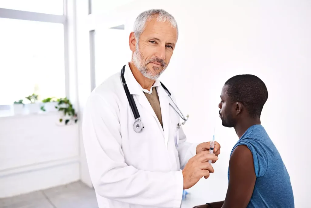 Doctor needle and man in hospital for vaccine healthcare and medicine