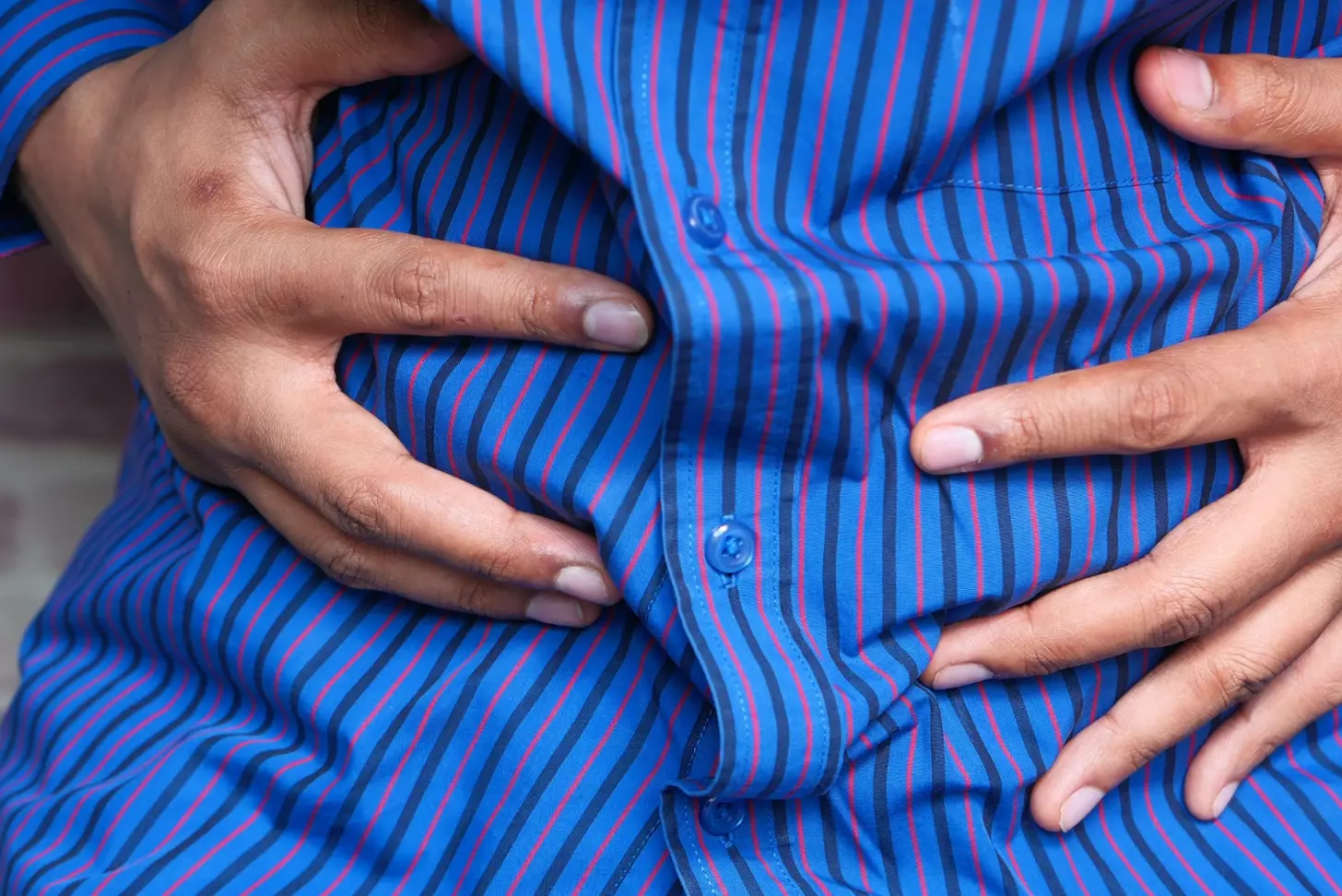 Young man suffering stomach pain close up.