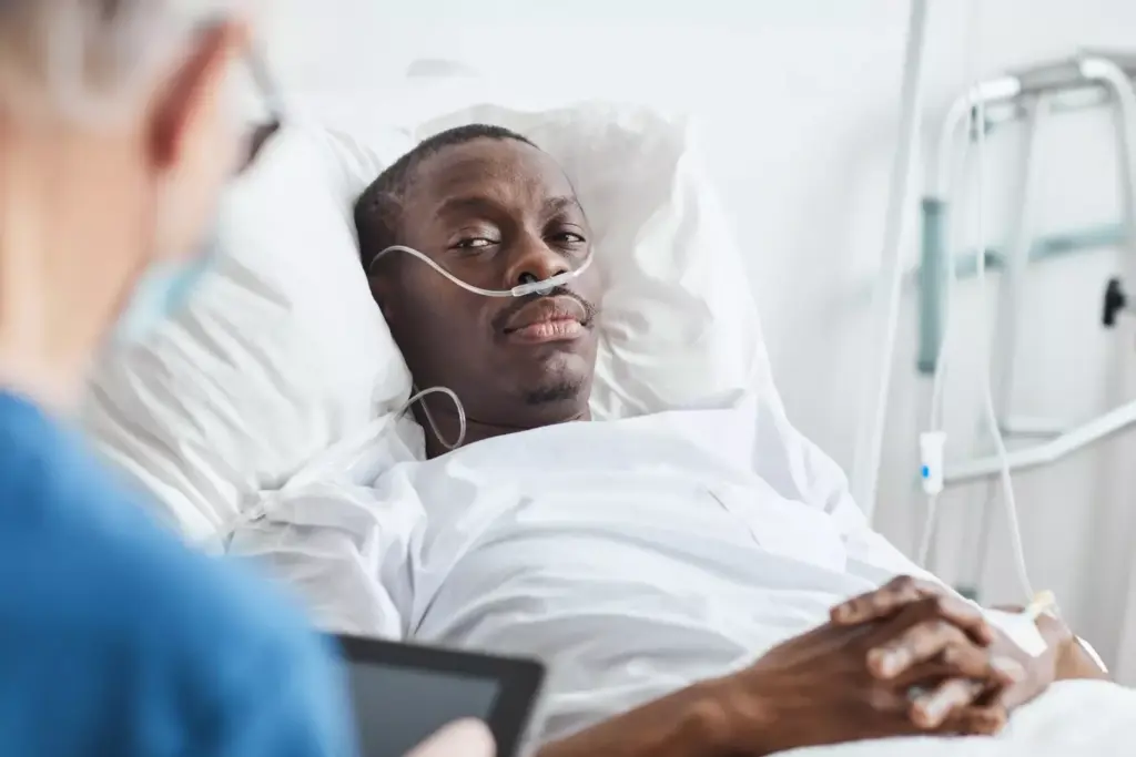 african-american man lying in hospital bed and looking at docto african-american man lying in hospital bed and looking at docto